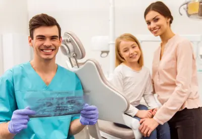 A dentist and two women sitting in front of a patient.