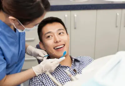 A dentist is examining the teeth of a patient.