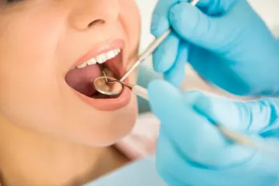 A woman getting her teeth cleaned by dentist.