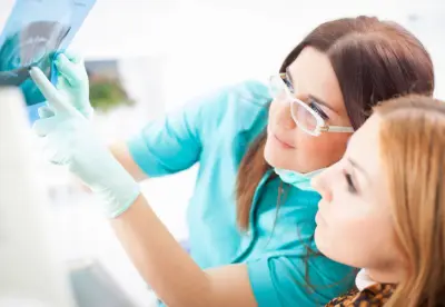 A woman and a dentist looking at something on the screen.