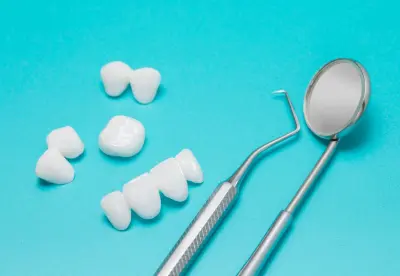 A tooth brush and dental mirror next to teeth.