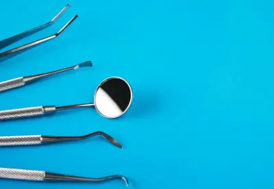 A group of dental instruments on top of a blue table.